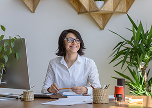 Happy desk worker with indoor plants on her desk